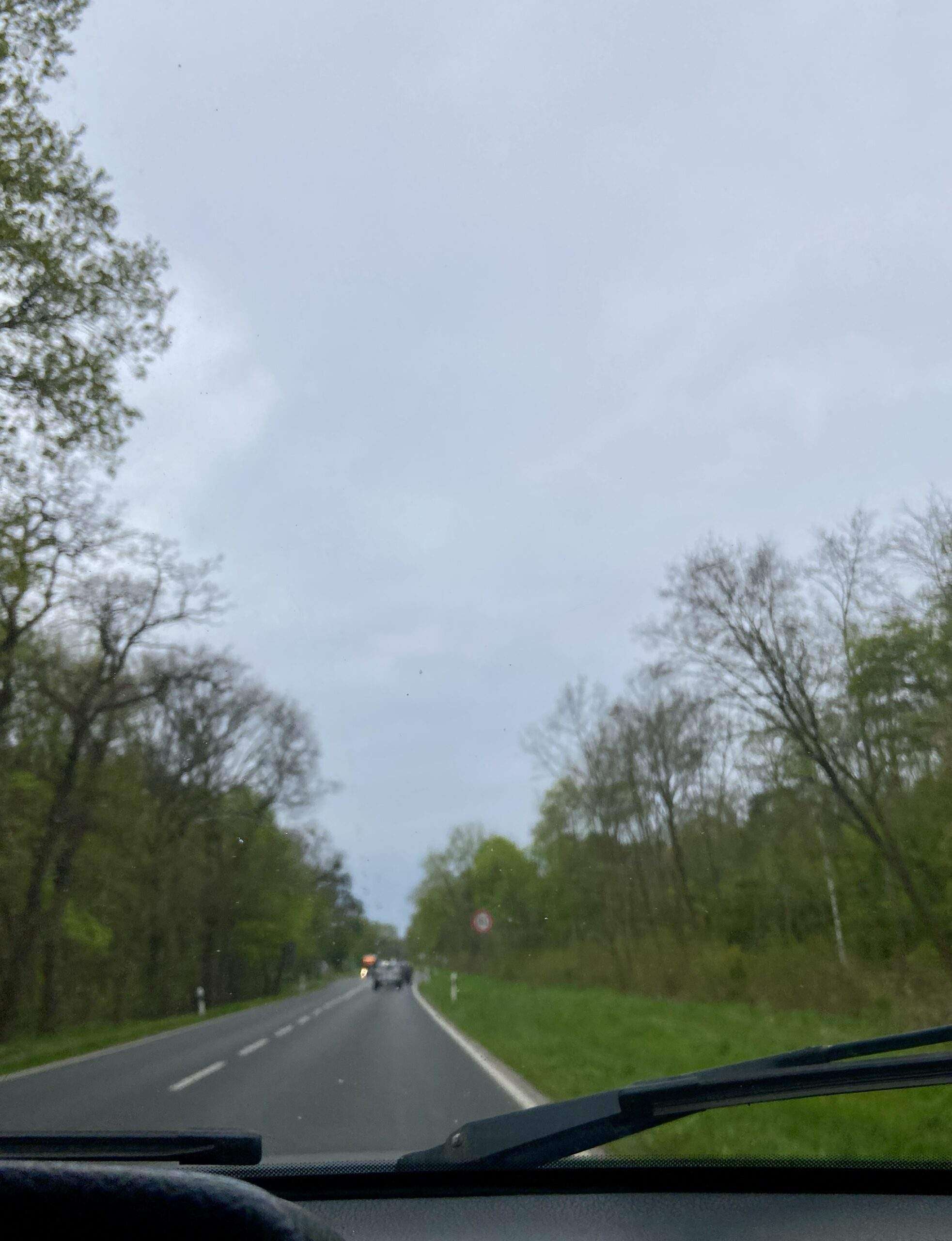 Blick durch die Windschutzscheibe auf die kaum befahrene Straße bei trüben Wetter