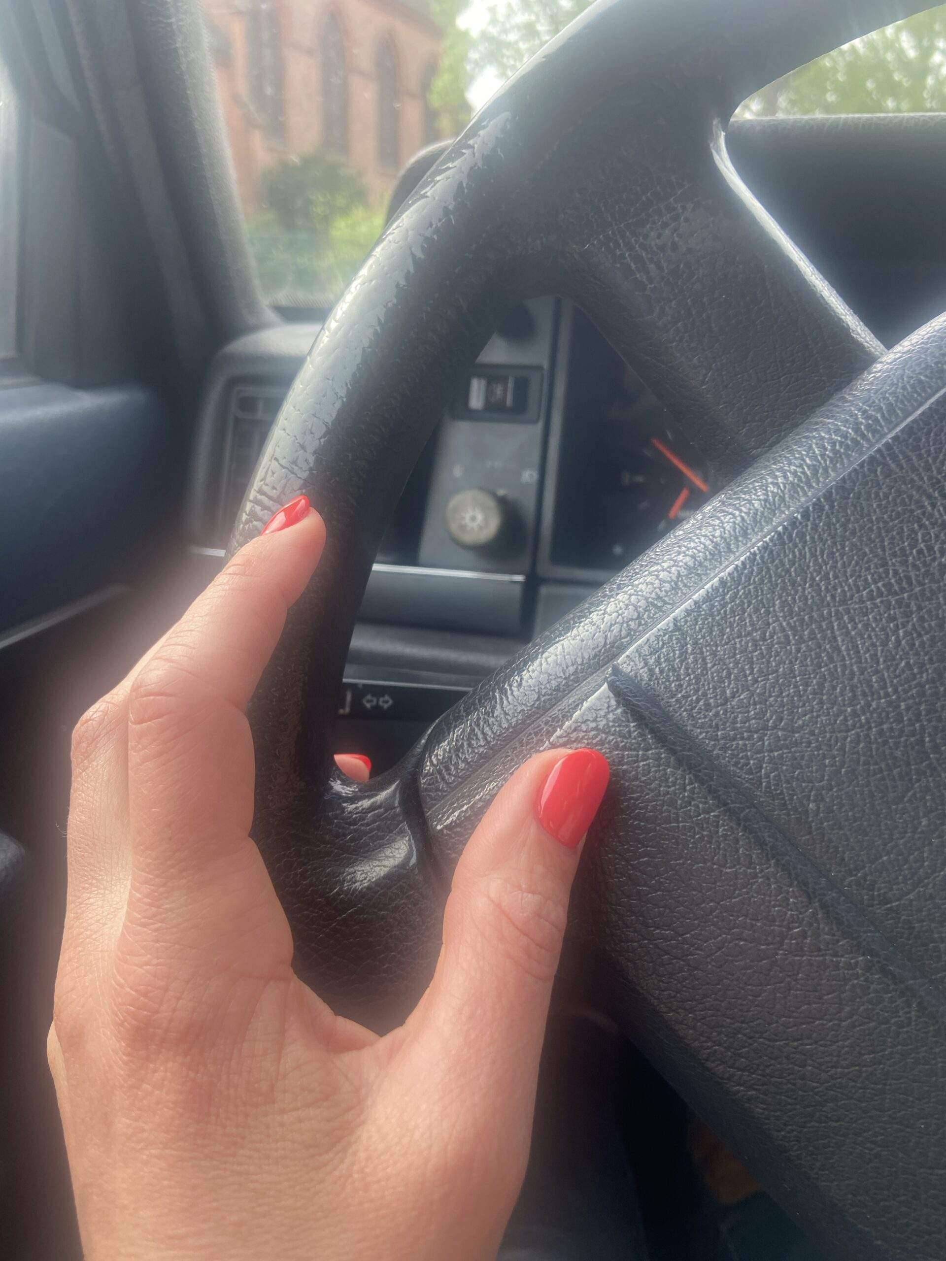 Gunhild Rudolphs Hand mit neuem, rotem Nagellack am Lenkrad