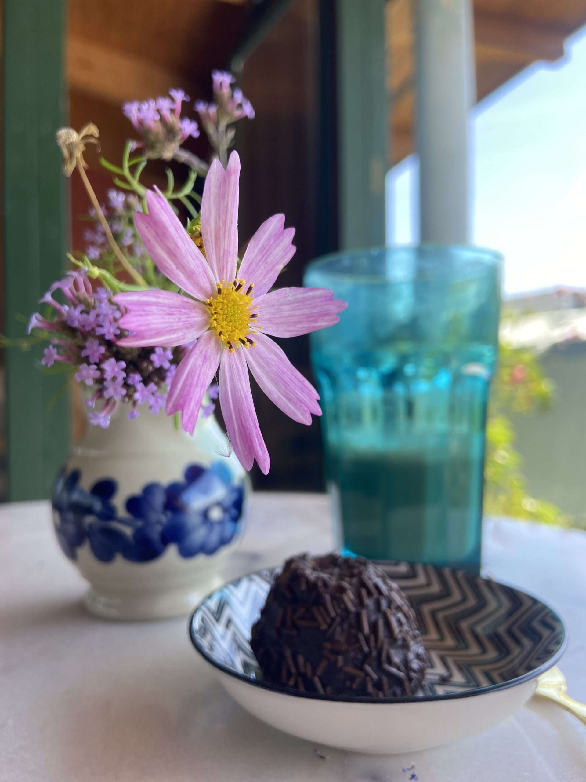 Schokoladen Dessert aus Schweden mit Kaffee und Blumenstrauß auf einem Marmortisch.