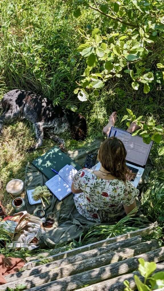 am Fuße der Kanzelleiter auf der Decke sitzend und am Laptop arbeitend